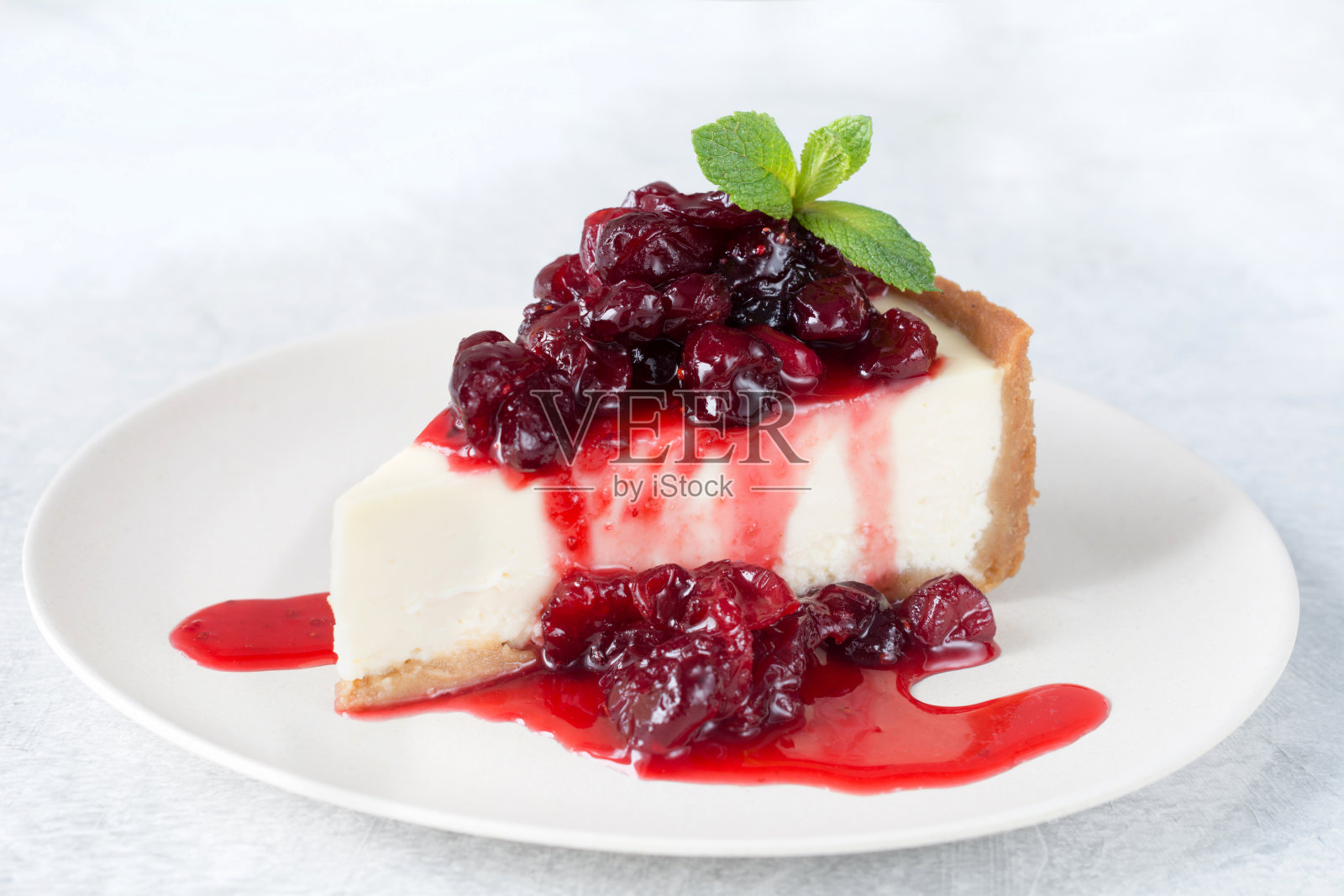 白盘子上的樱桃酱芝士蛋糕照片摄影图片