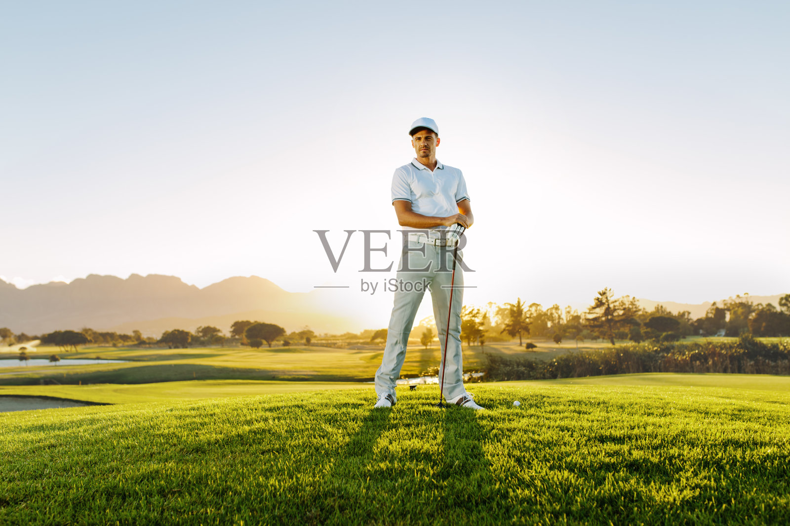 男高尔夫球手站在高尔夫球场上照片摄影图片