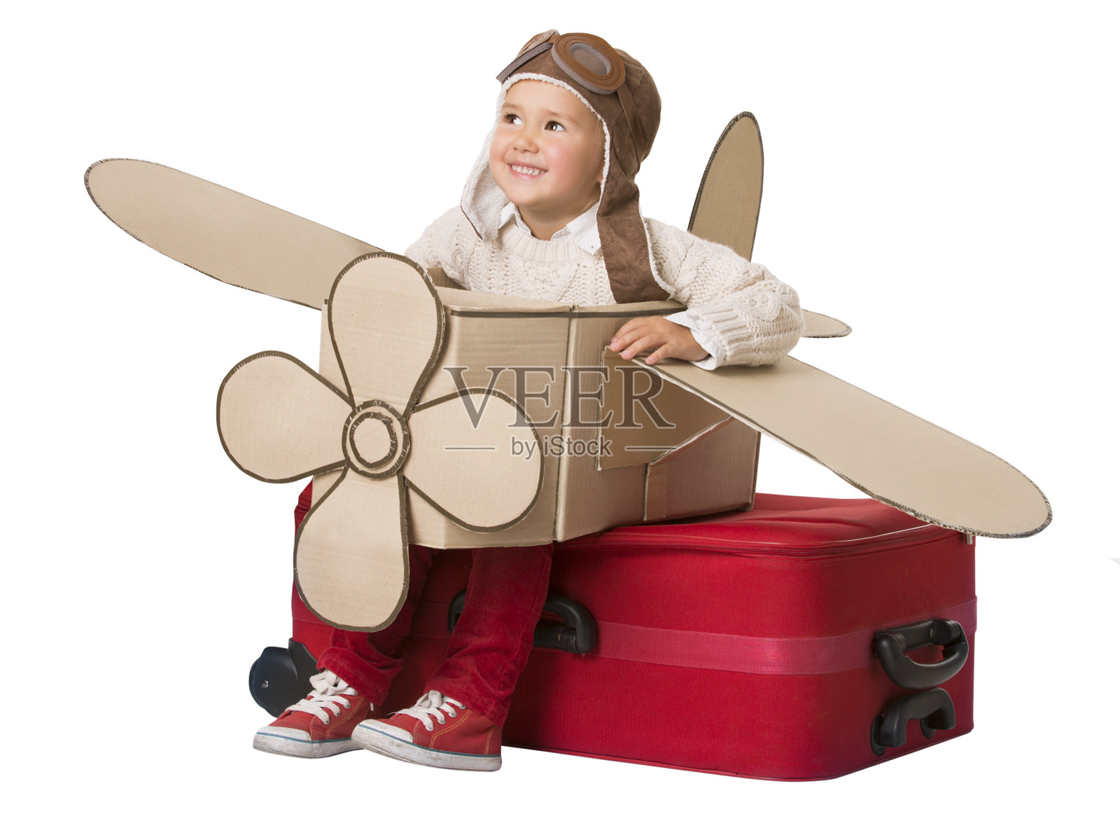 孩子在玩具飞机上旅行，孩子坐在手提箱上，行李作为飞机飞行，婴儿飞行员照片摄影图片