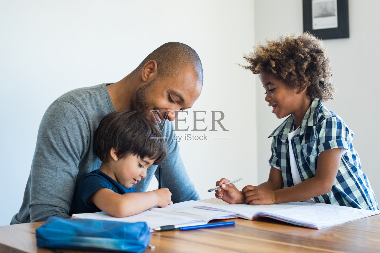 父亲帮助他的儿子做家庭作业照片摄影图片