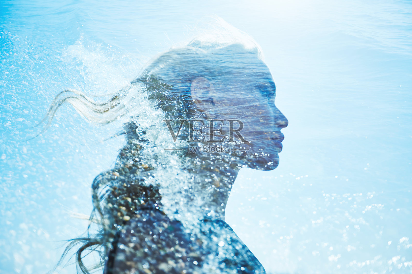 一个女孩在蓝色的海浪夏天的肖像。美丽的金发在海的背景，暑假在海上。一个神秘的女孩在海上泡沫照片摄影图片
