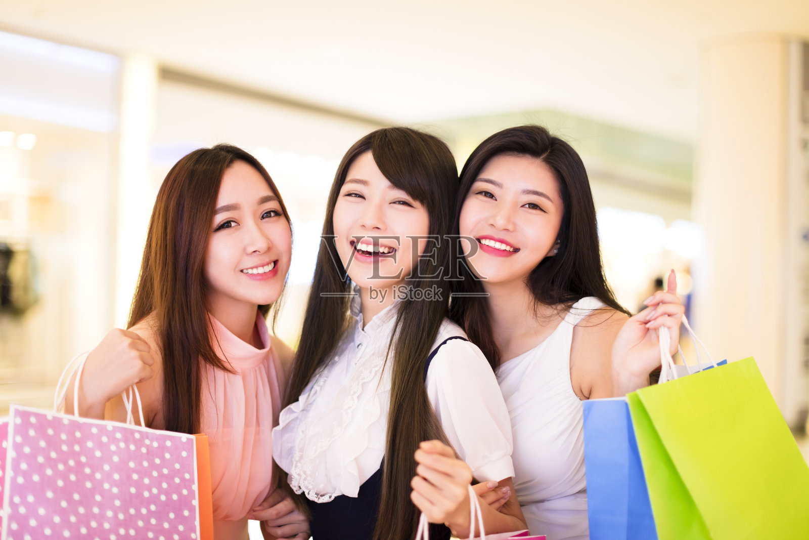 快乐的女人群拿着购物袋在商场照片摄影图片