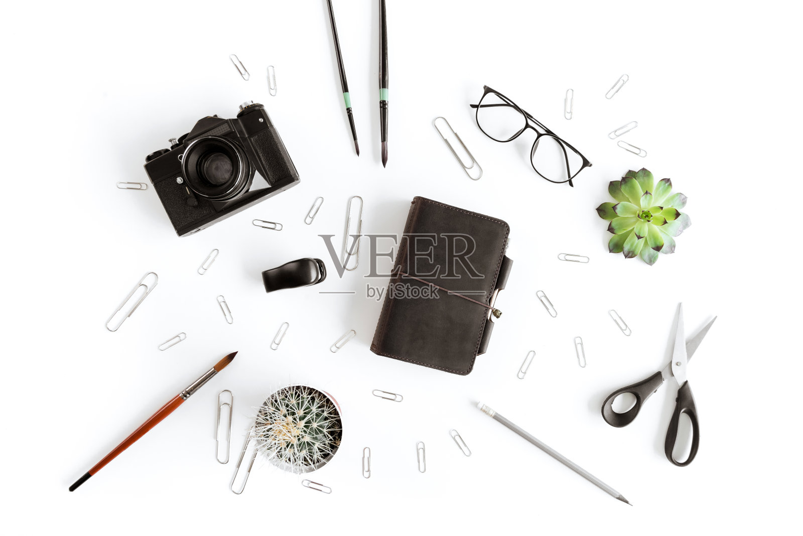 俯视图钱包，相机和各种办公用品和植物孤立在白色照片摄影图片