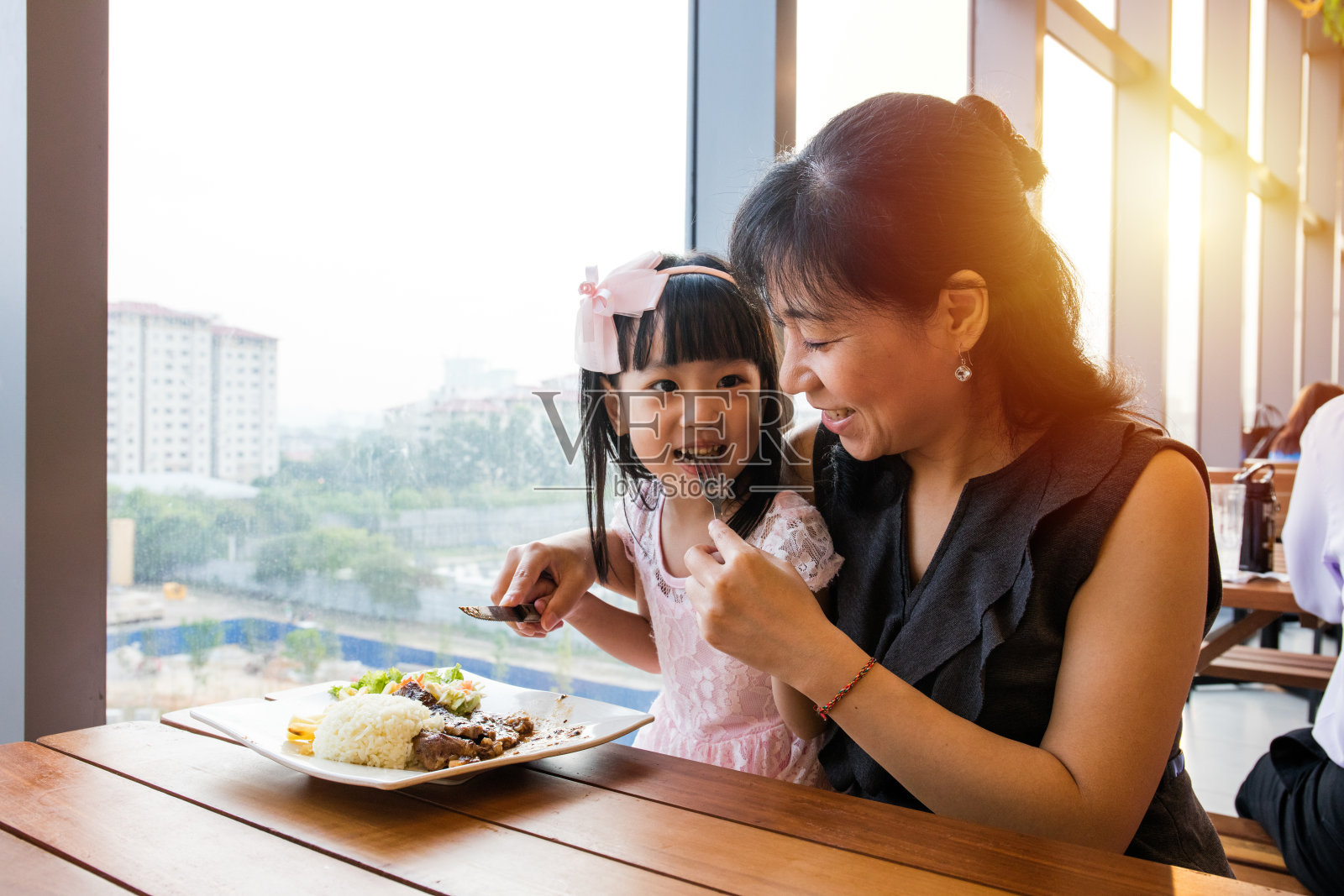 亚裔华人母亲和女儿在吃牛排照片摄影图片