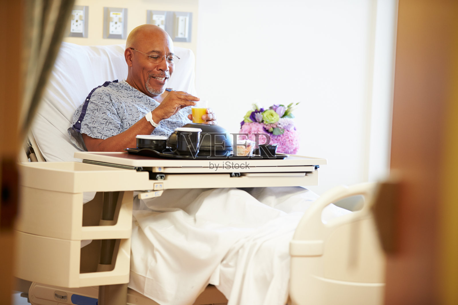 老年男性患者在病床上用餐照片摄影图片