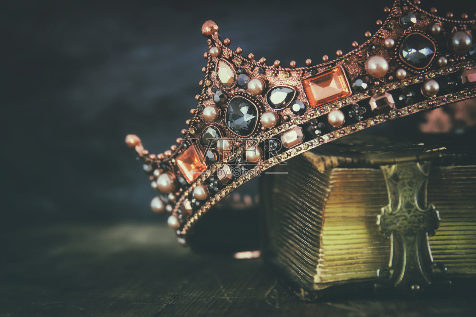 在旧书上美丽的女王/国王王冠的低调形象照片摄影图片