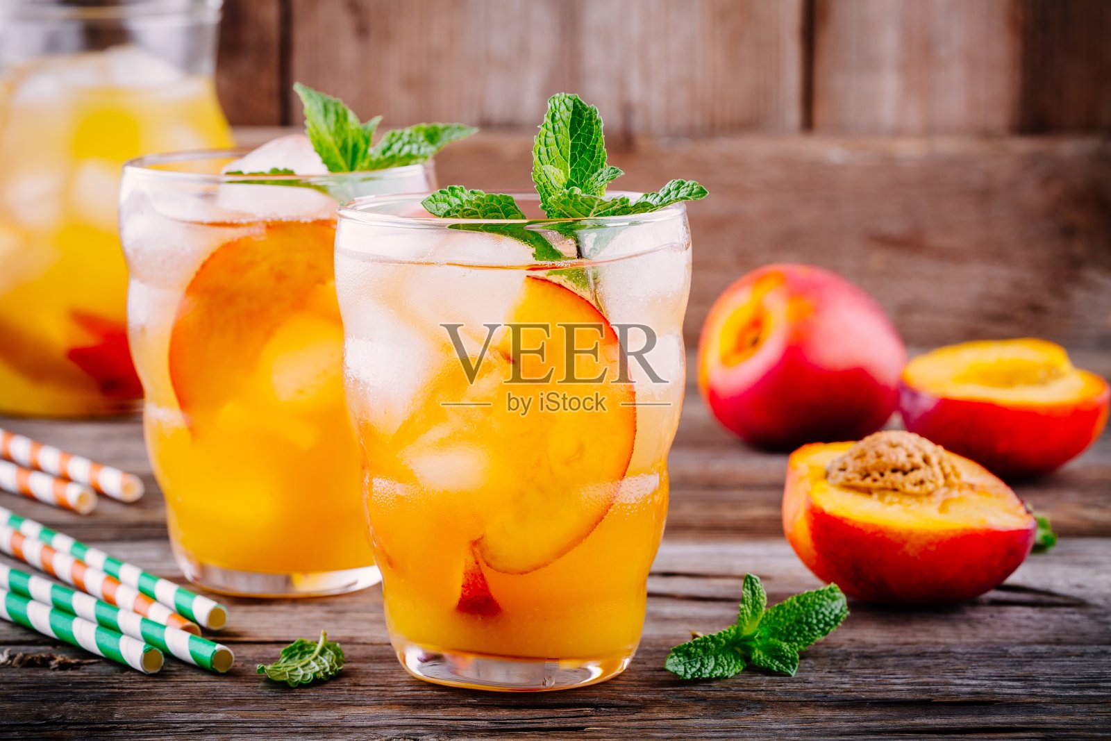 夏季冷饮:自制水蜜桃柠檬水加冰块和薄荷杯照片摄影图片