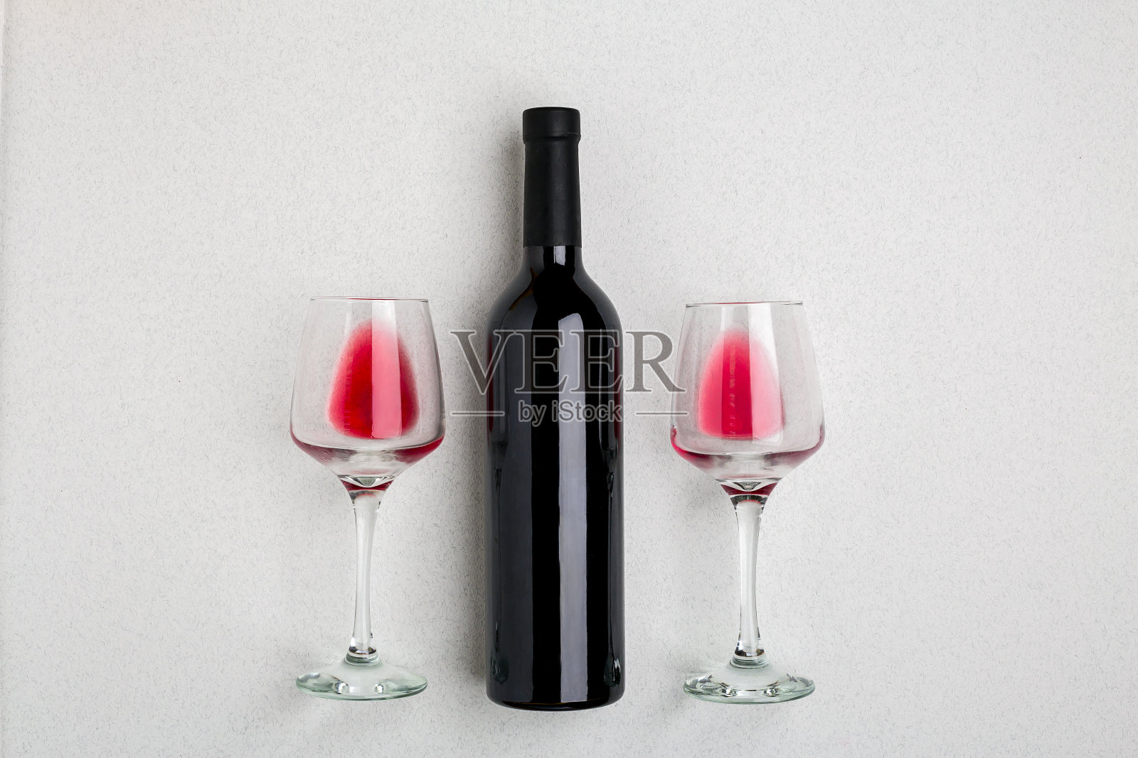 头顶上的一个大瓶红酒的角度视图，酒杯在白色的背景照片摄影图片