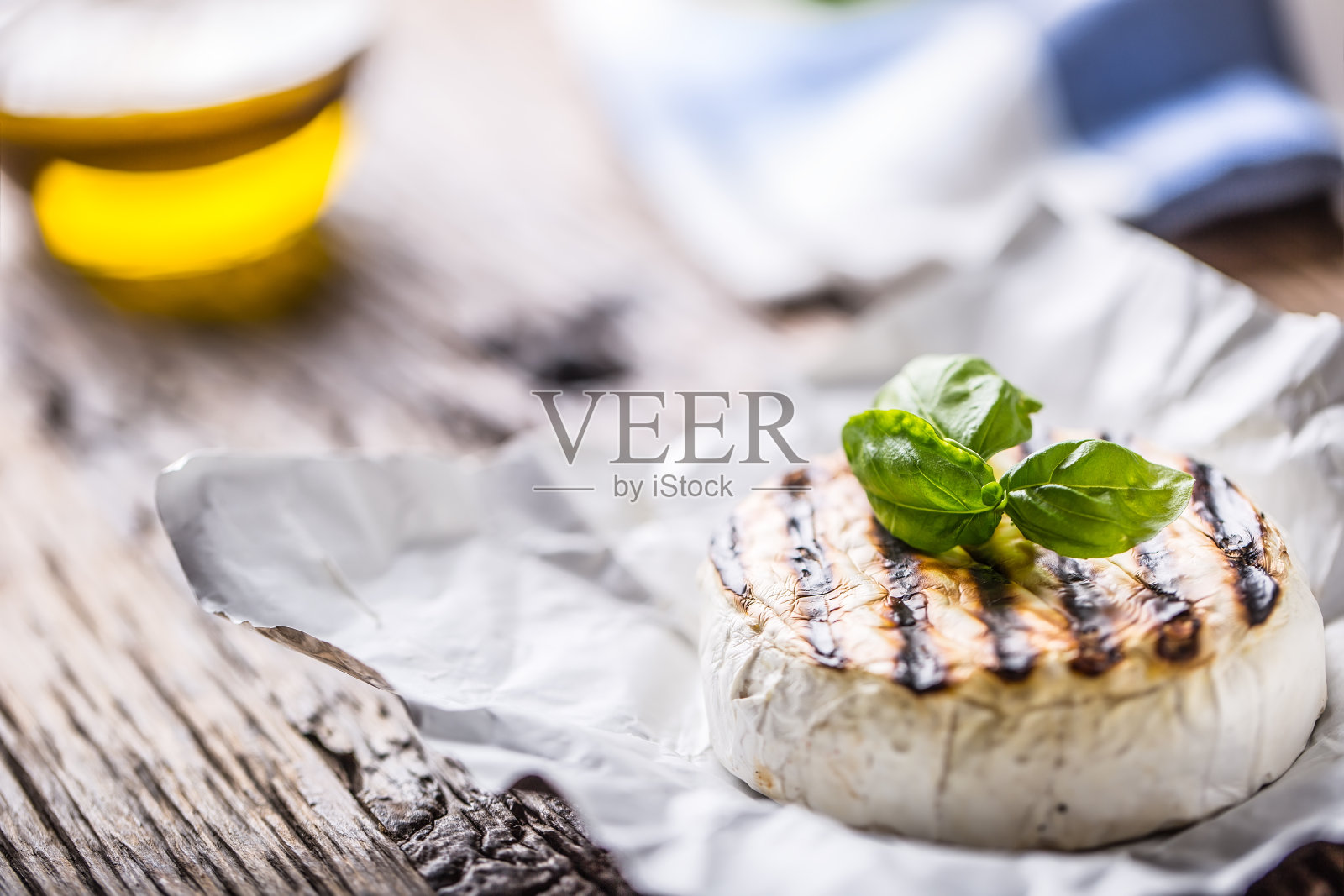 卡蒙伯尔的奶酪。烤卡门贝尔奶酪配橄榄油和罗勒叶照片摄影图片