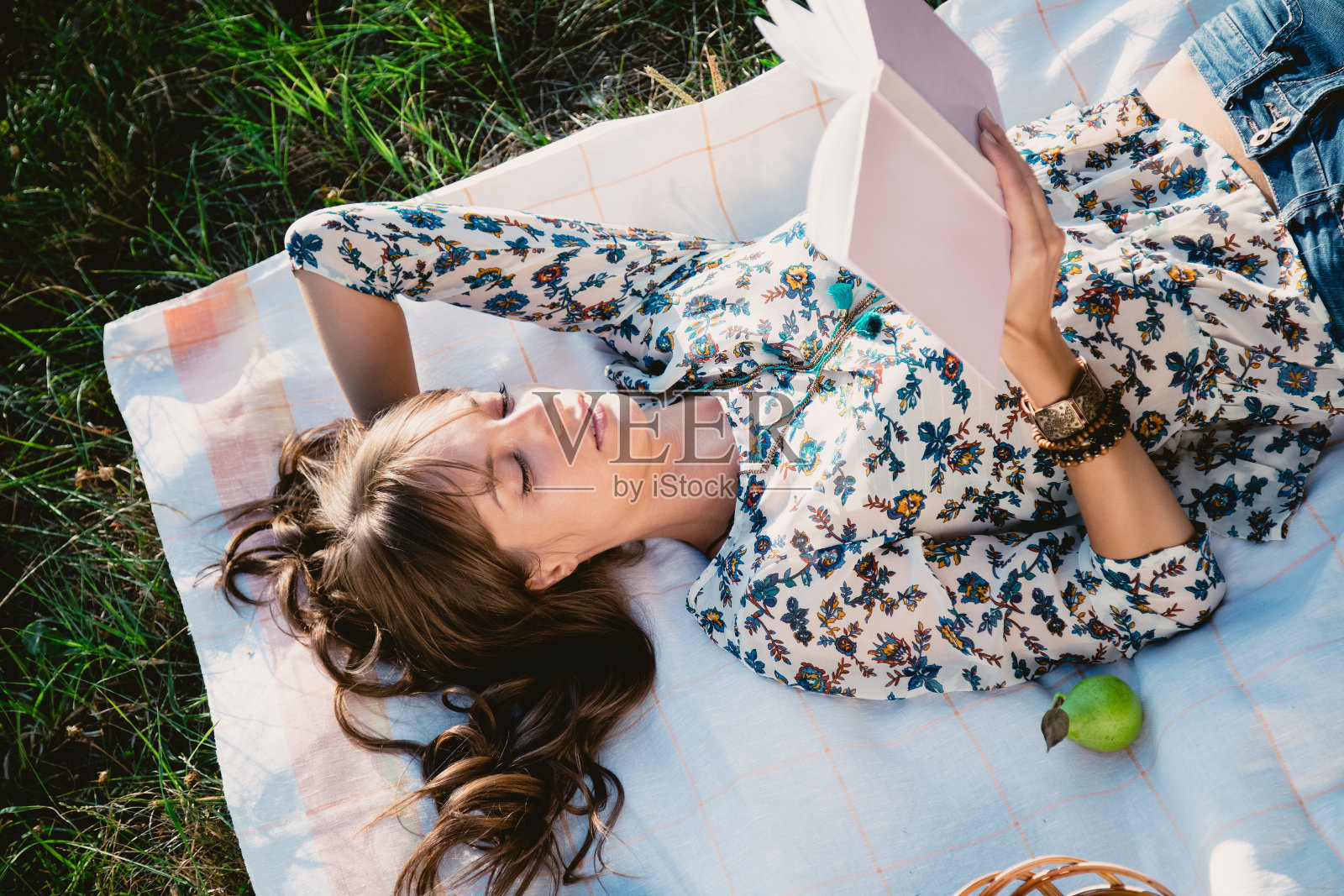 女孩躺在公园里看书照片摄影图片