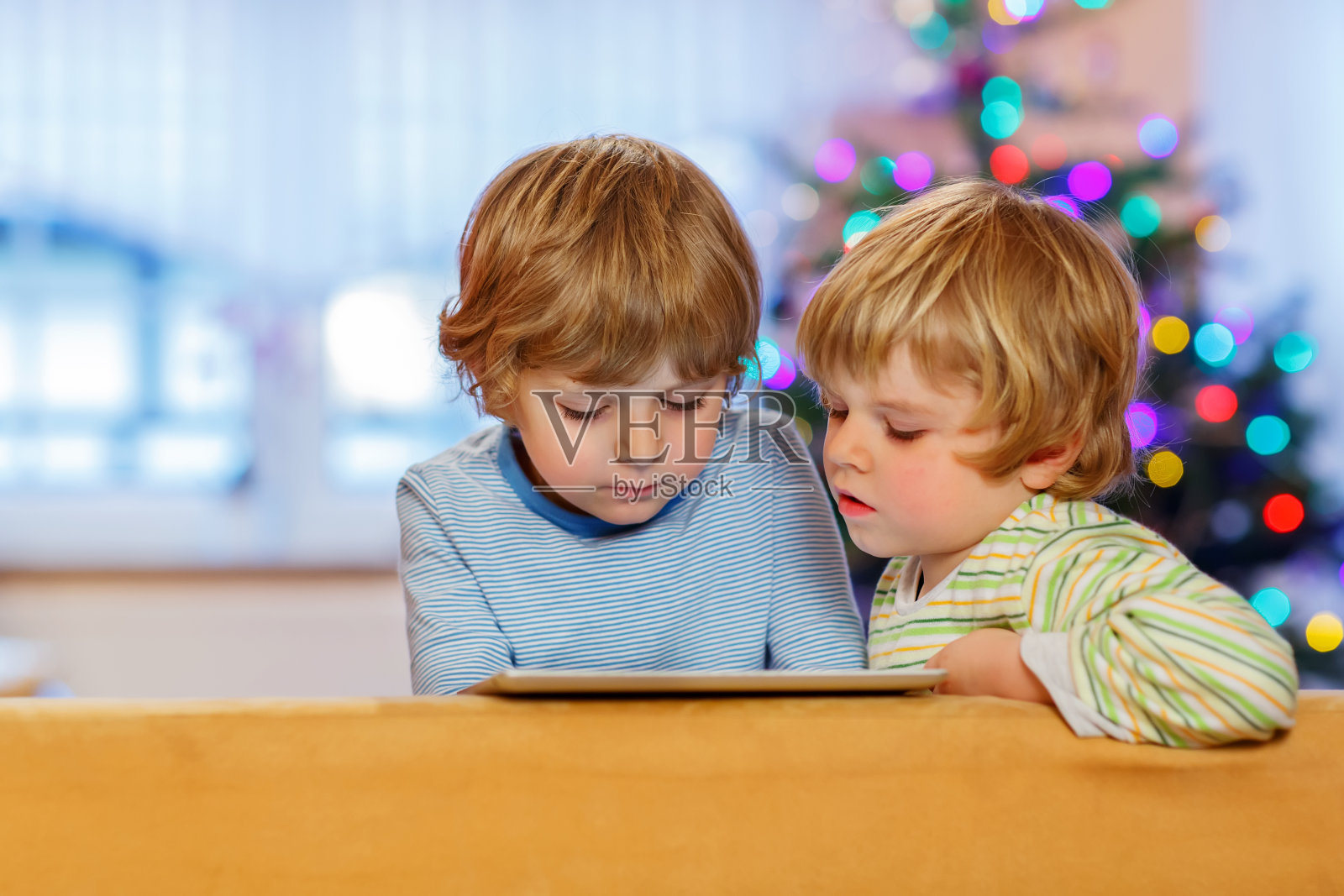 两个快乐的孩子在室内玩平板电脑照片摄影图片