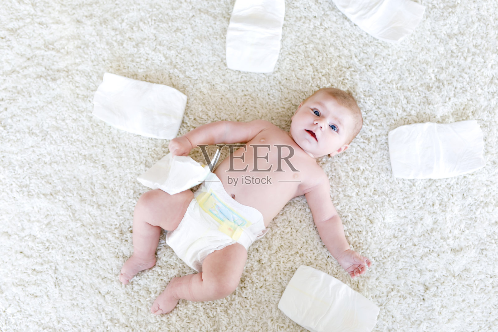 刚出生的女婴穿着尿布。干性皮肤及保育照片摄影图片