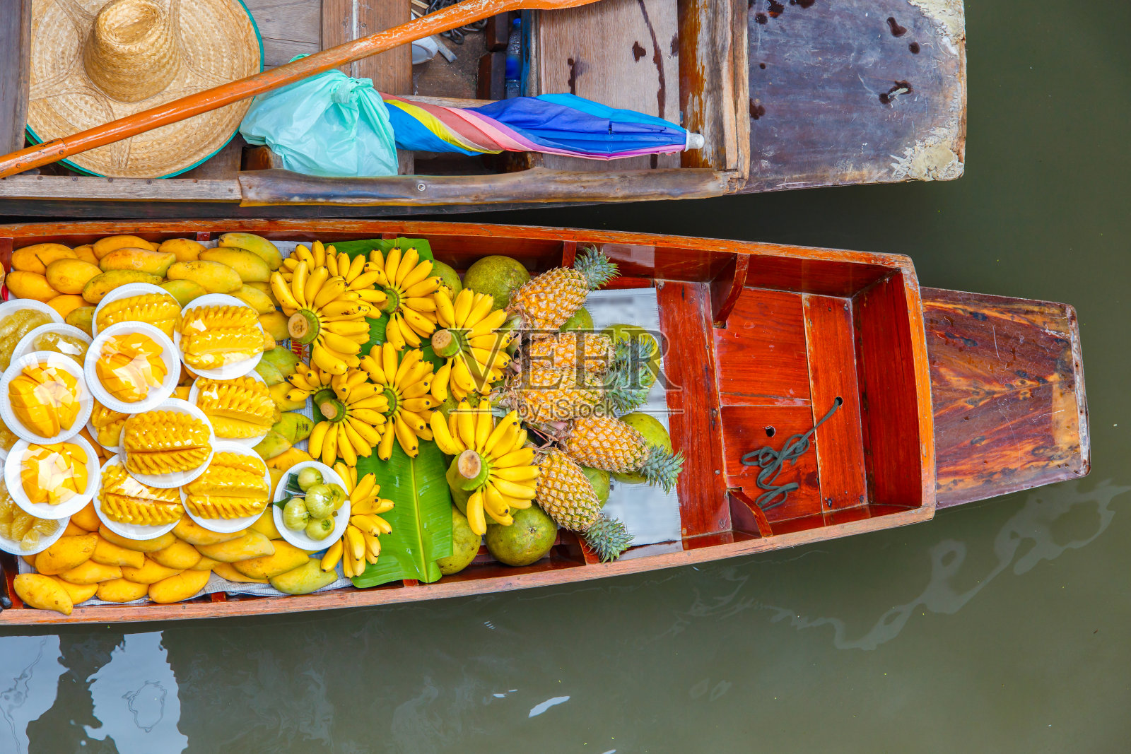 泰国曼谷附近的Ratchaburi浮动市场上的长尾船和水果照片摄影图片