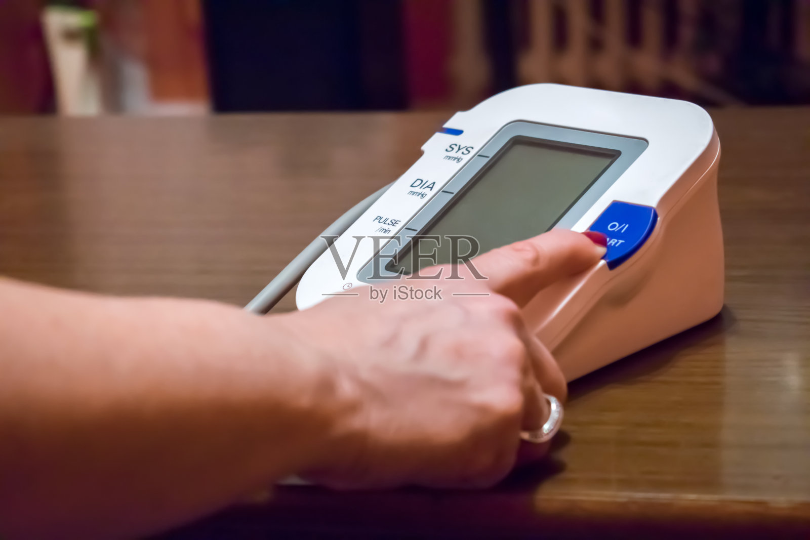 测量血压，女性手指按下开始按钮照片摄影图片