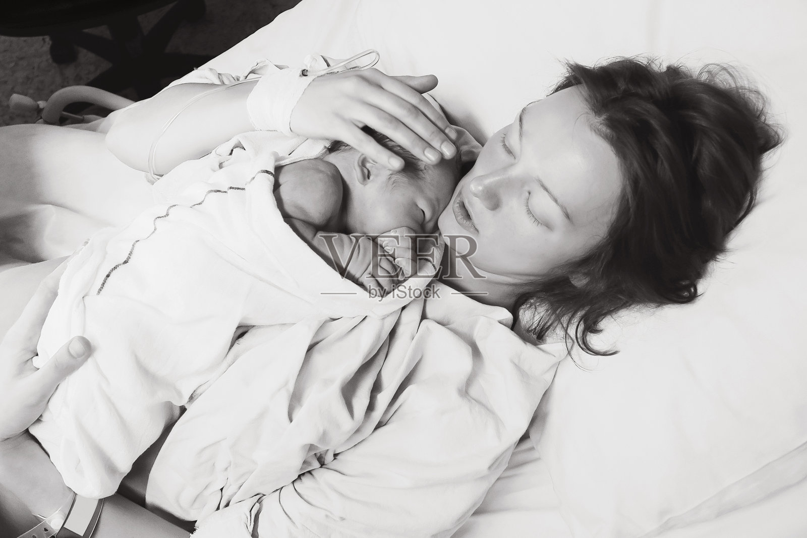在医院里，母亲抱着刚出生的孩子。照片摄影图片