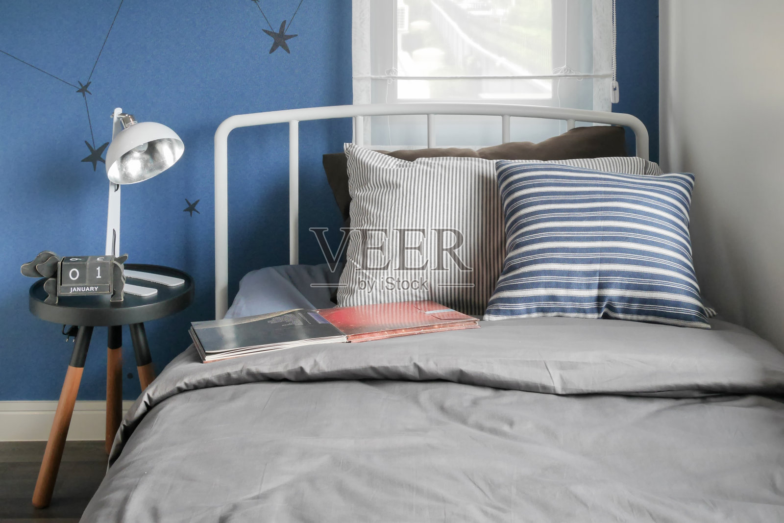 米色和条纹枕头在现代风格的床设置和蓝色墙壁卧室照片摄影图片