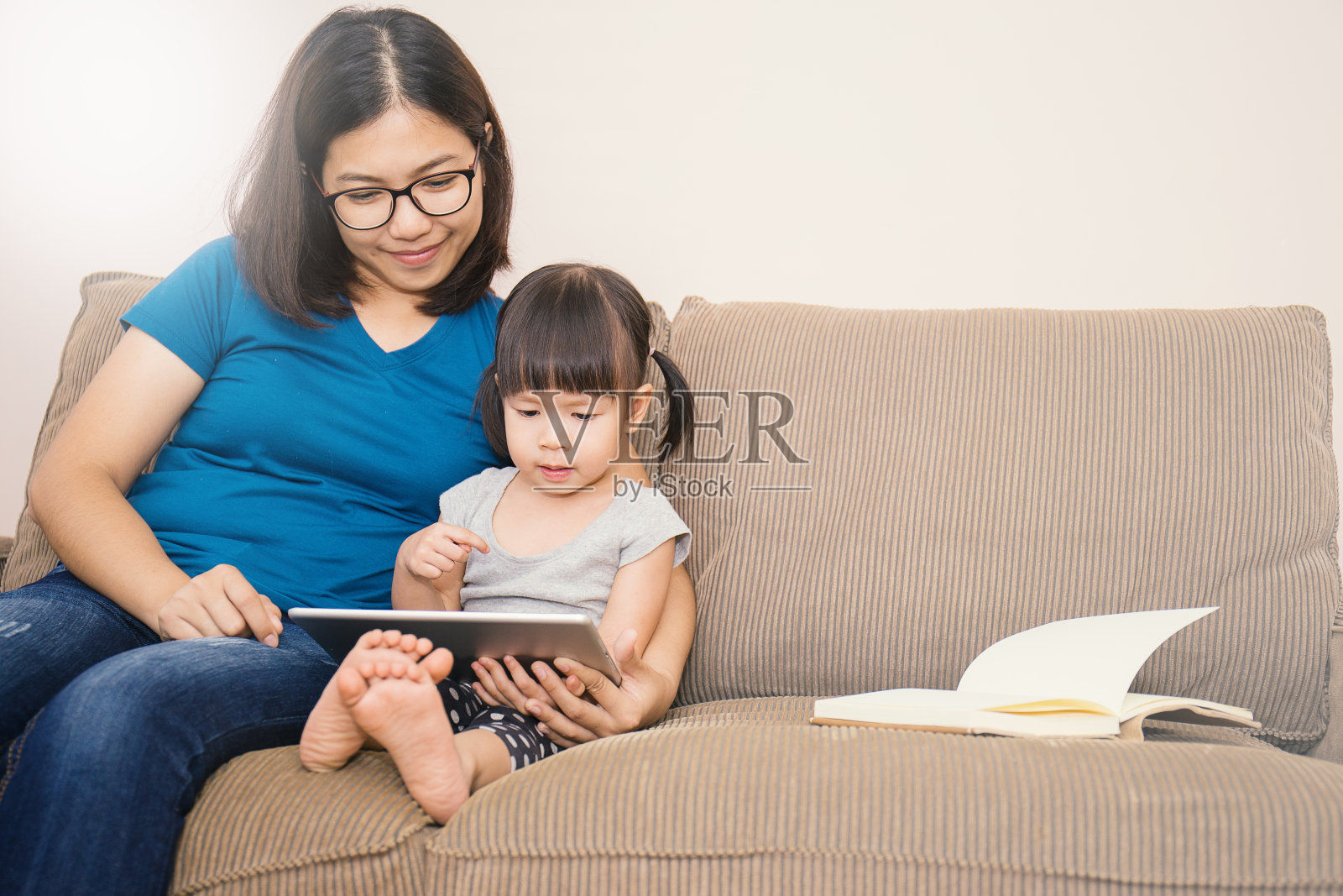 一个亚洲家庭拿着一台平板电脑看着它照片摄影图片