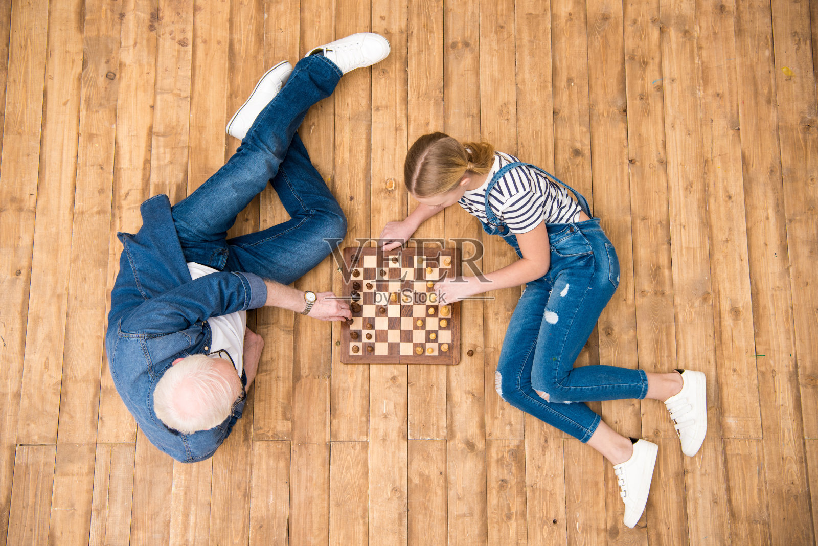 俯视图爷爷和孙女在硬木地板上下棋照片摄影图片
