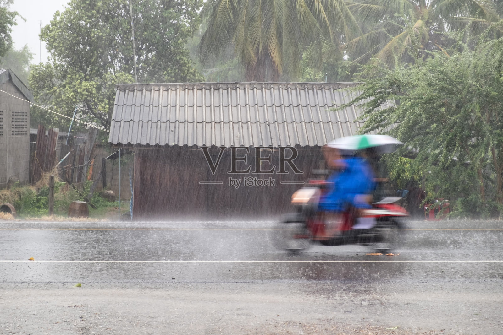 摩托车在狂风暴雨中飞驰，撞在木屋前面照片摄影图片
