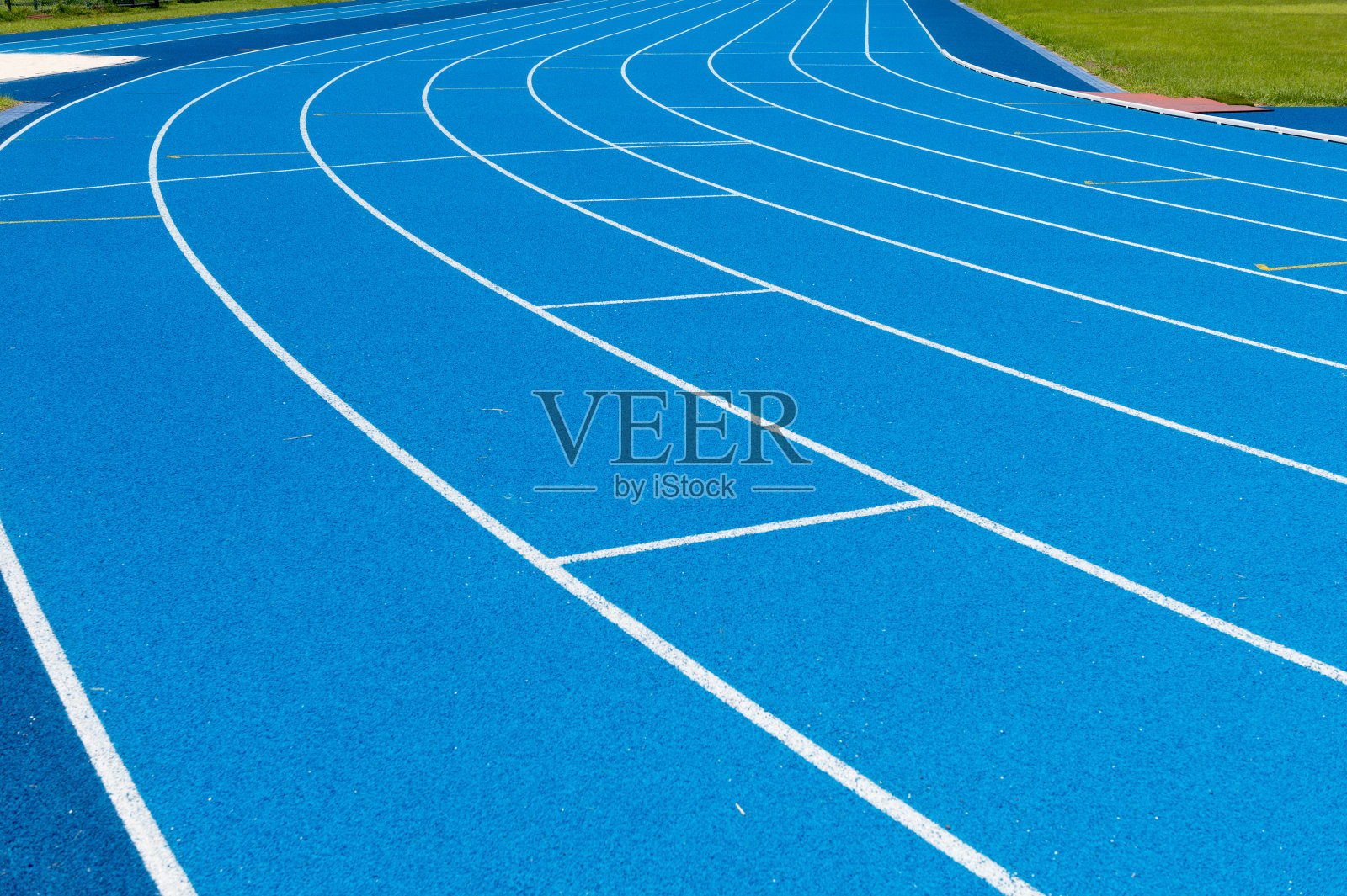 蓝色跑道。一条条蓝色跑道。户外体育场内有蓝色沥青和白色标记的跑道。有选择性的重点。照片摄影图片