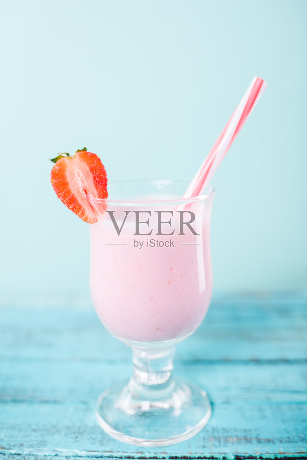 近距离观看美味的草莓奶昔在玻璃杯与饮用吸管照片摄影图片