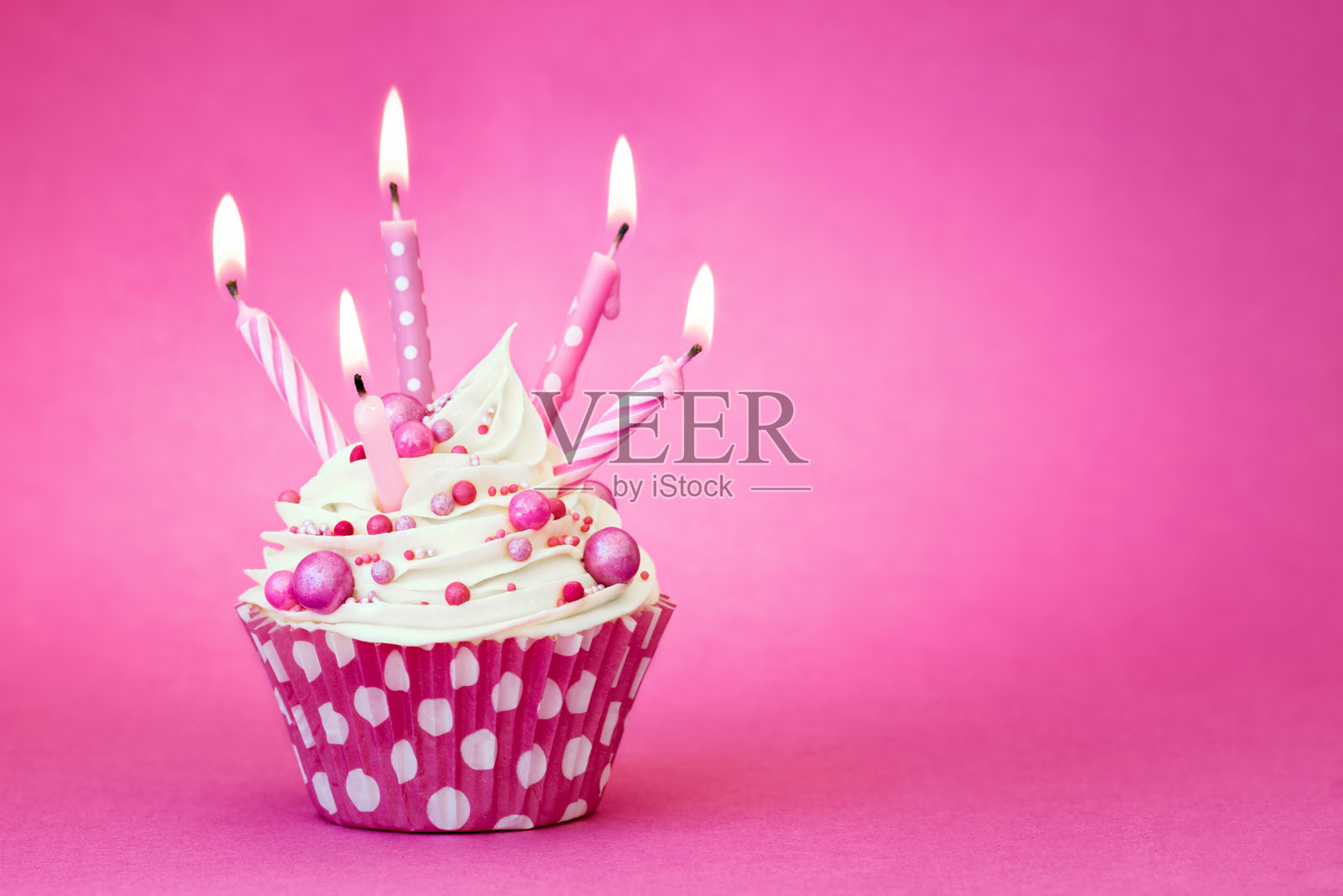 粉色生日蛋糕，粉色背景上插蜡烛照片摄影图片