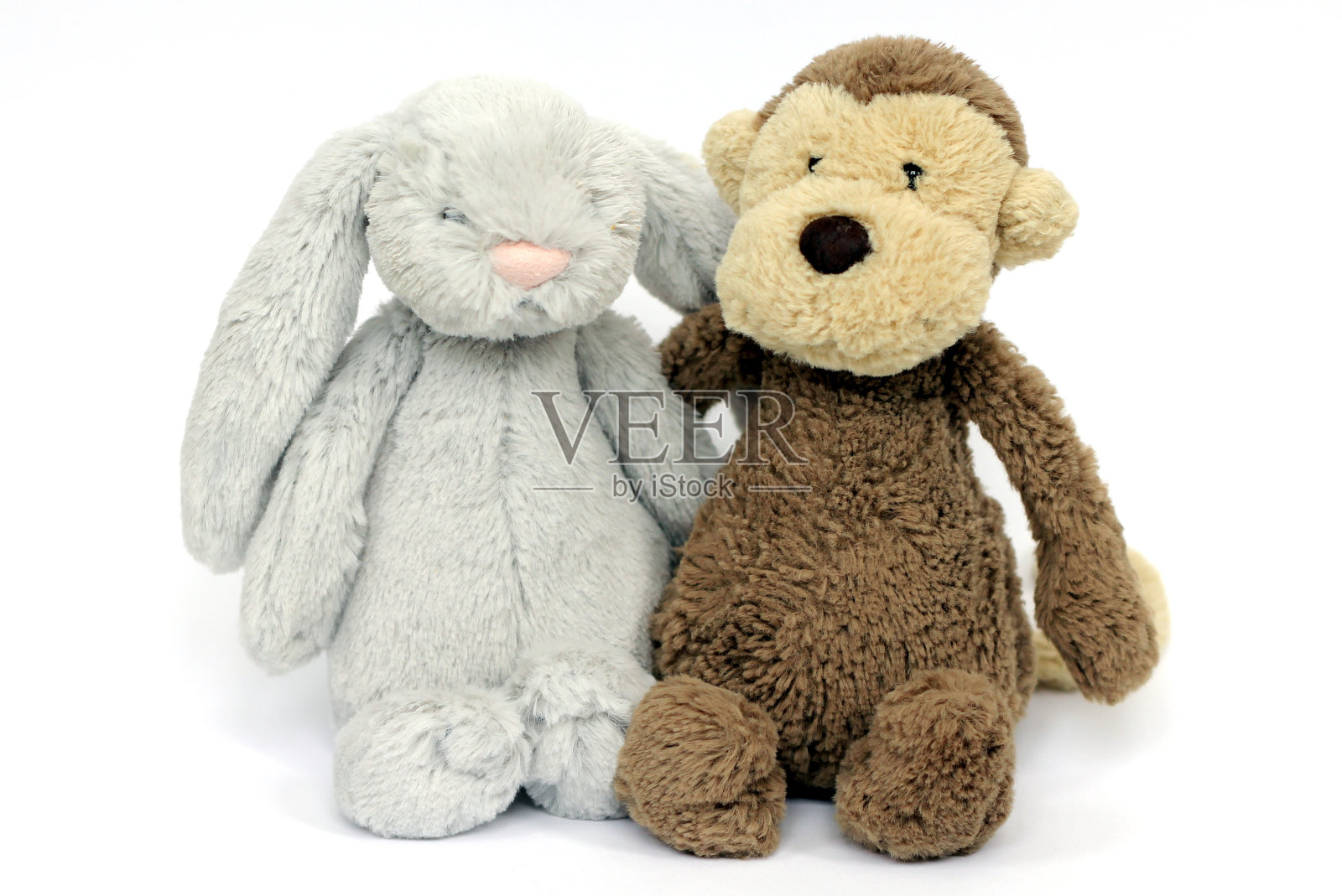 一个毛茸茸的灰色兔子和柔软的棕色猴子玩具照片摄影图片
