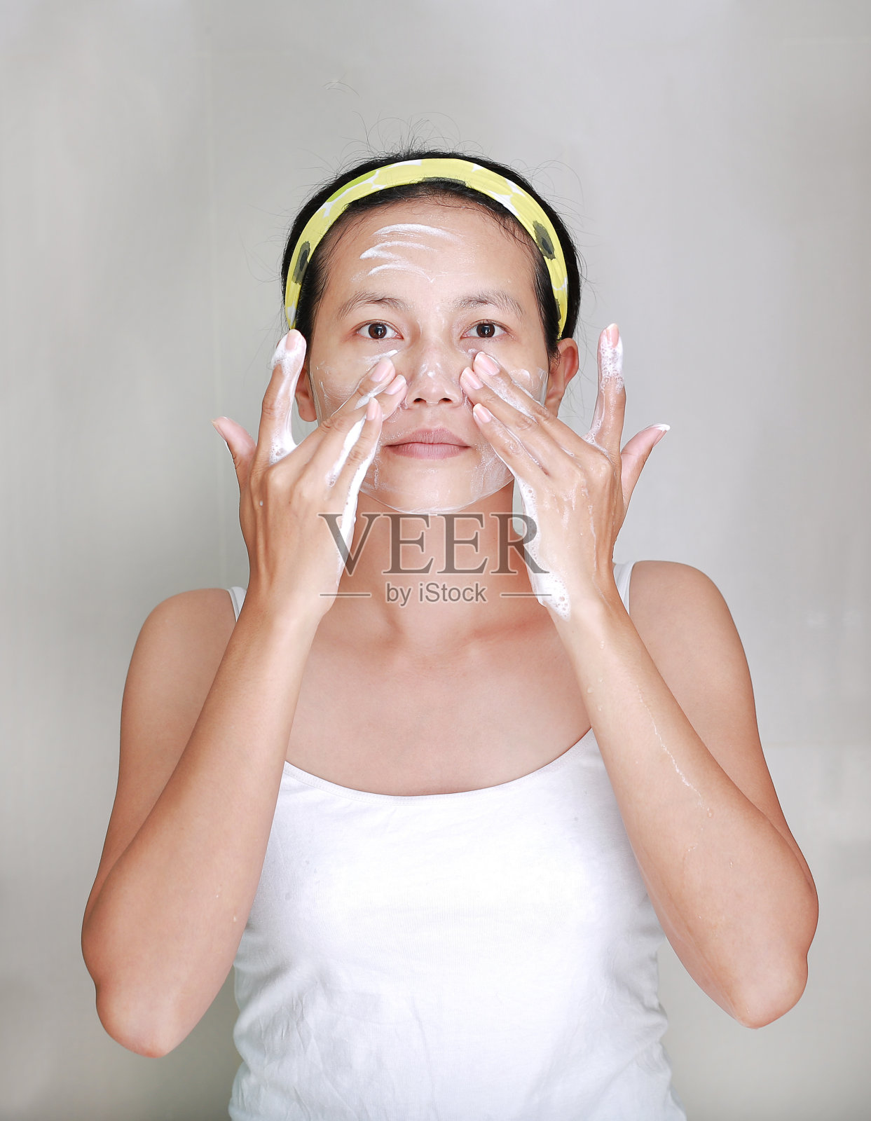 女人在脸上涂抹泡沫霜照片摄影图片