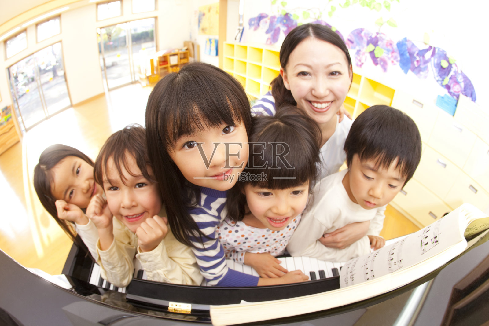 幼儿园和幼儿园在钢琴前微笑照片摄影图片