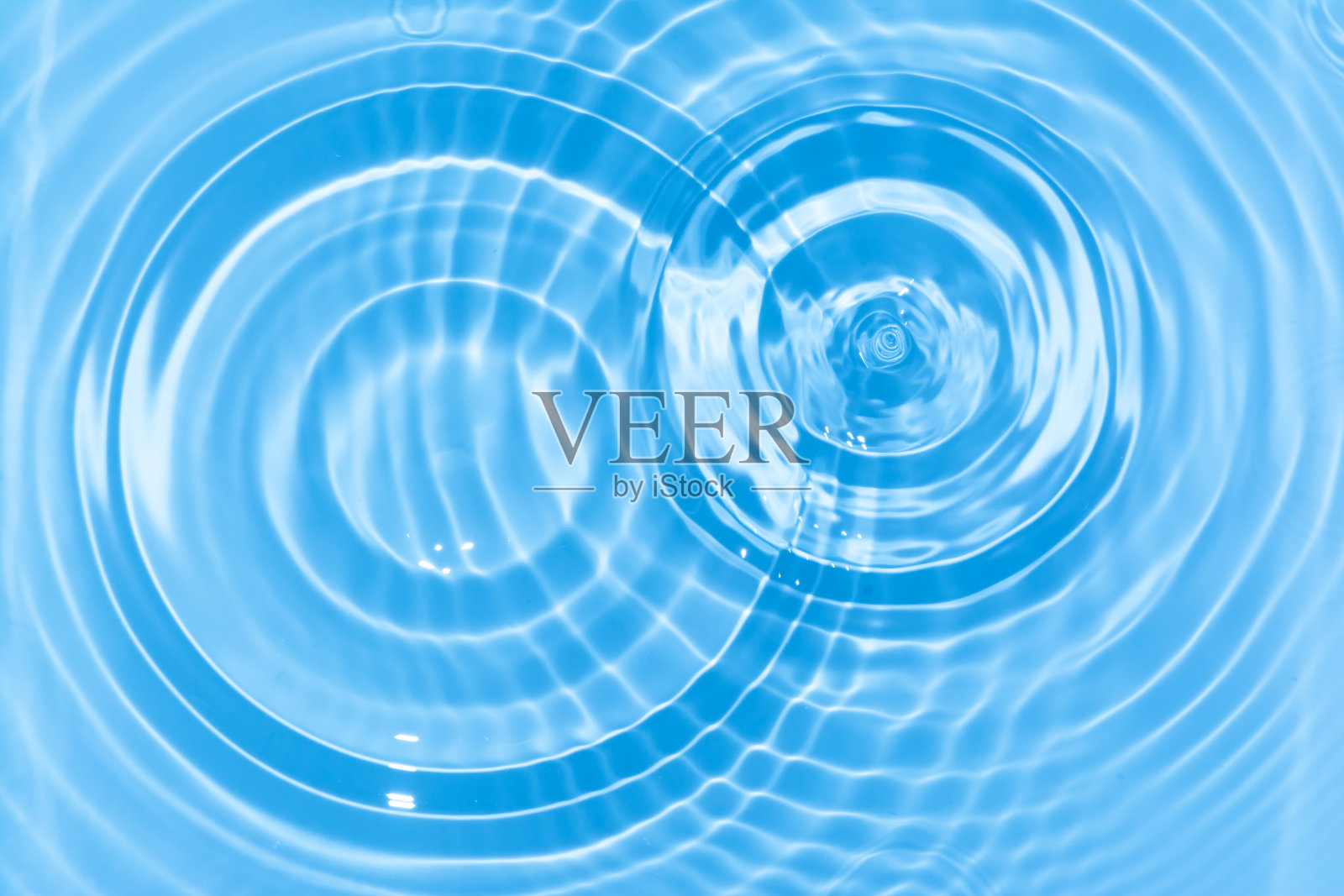 抽象的蓝色圆水滴波纹。液体纹理背景。照片摄影图片