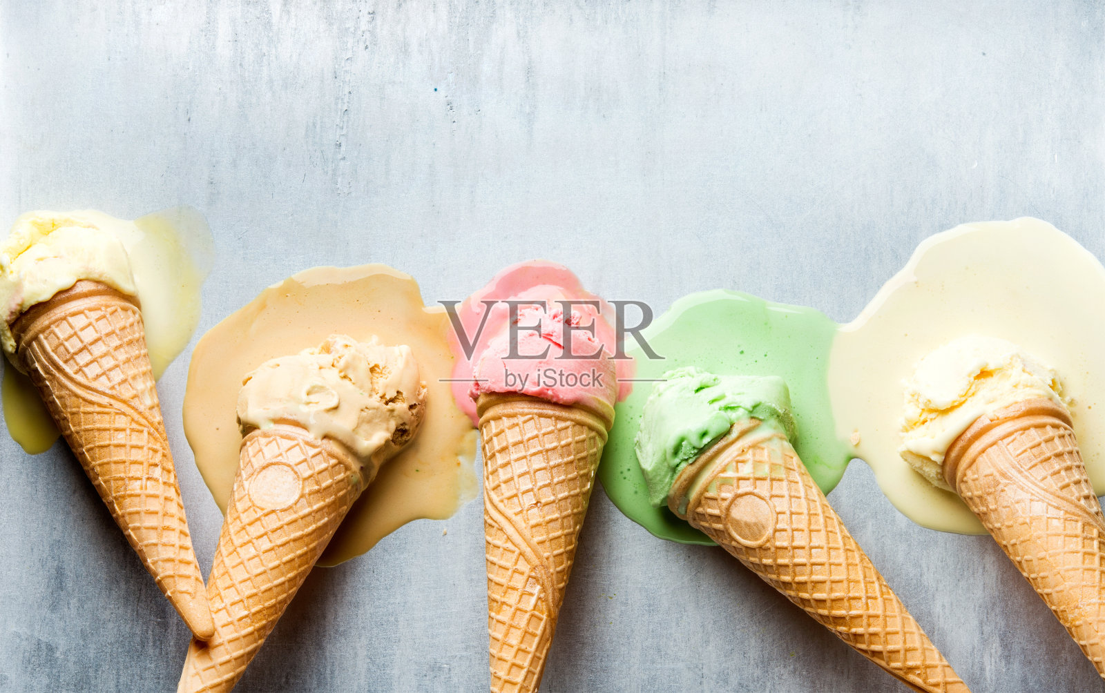 五颜六色的甜筒冰淇淋，不同的口味。融化的独家新闻。俯视图，钢金属背景照片摄影图片