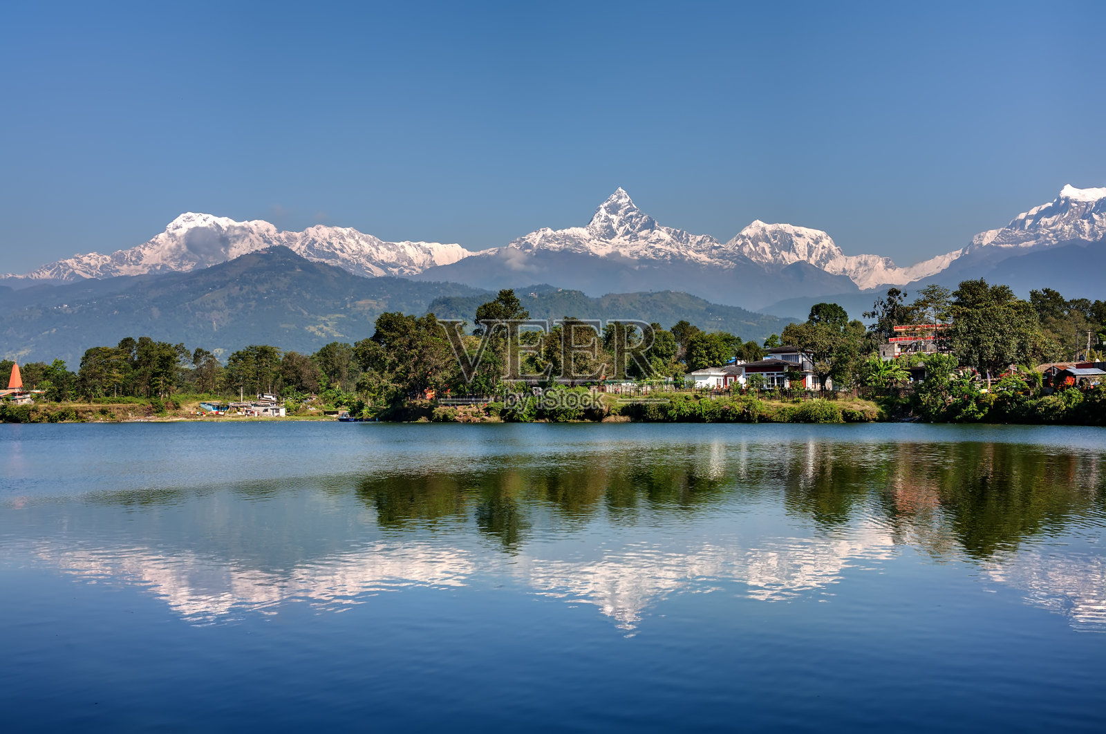 在尼泊尔博卡拉的安纳布尔纳山脉和它在费瓦湖的反射照片摄影图片
