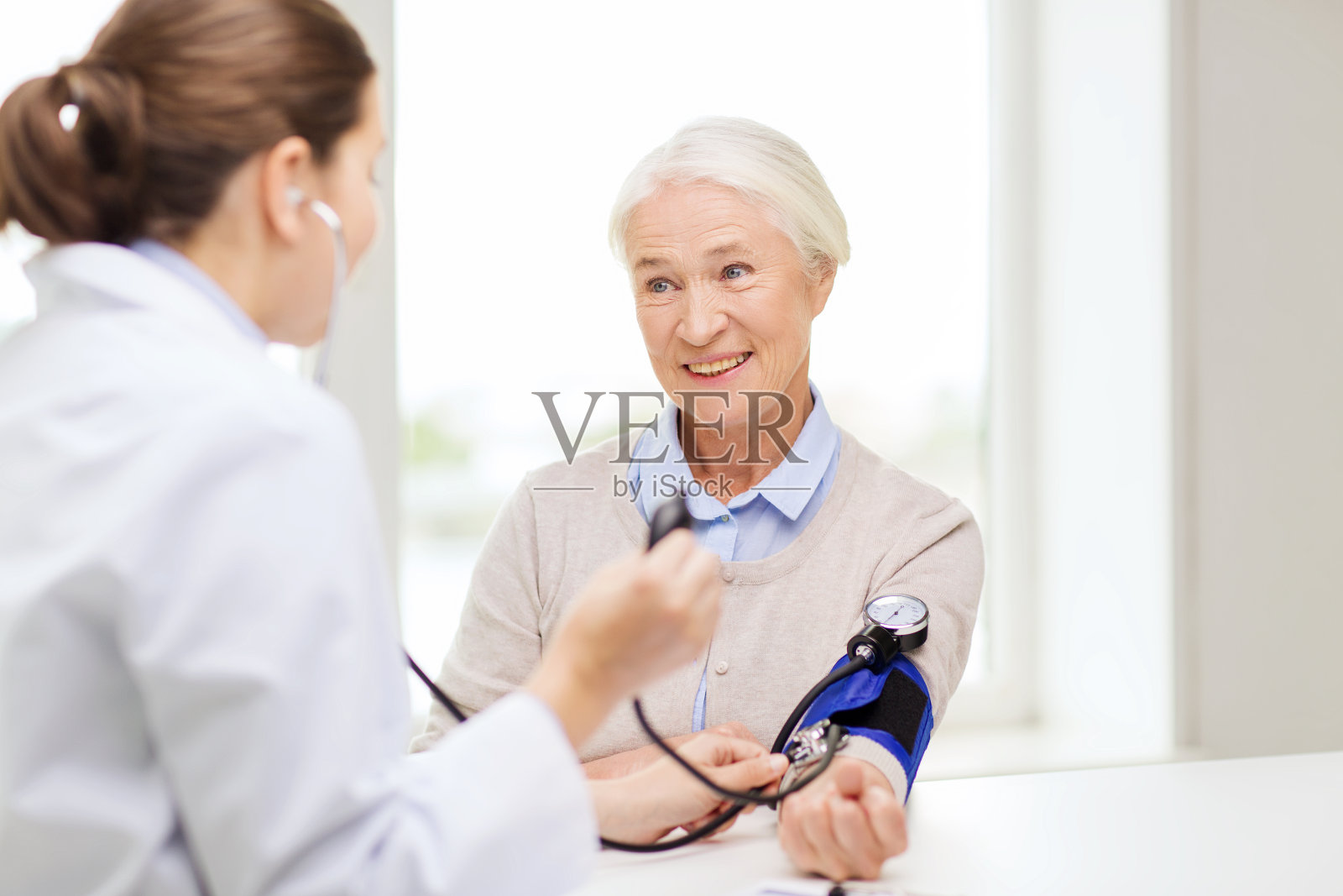 医生与血压计和资深妇女在医院照片摄影图片