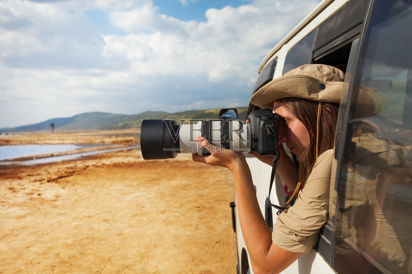 女孩在吉普车上拍摄非洲大草原照片摄影图片