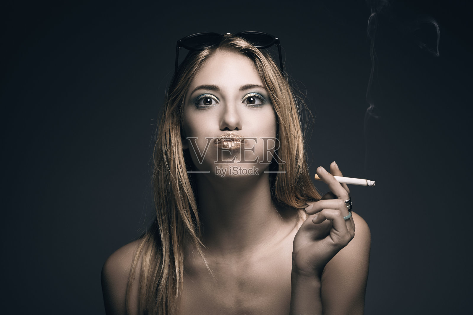 有趣的肖像年轻性感的女人，而吸烟照片摄影图片