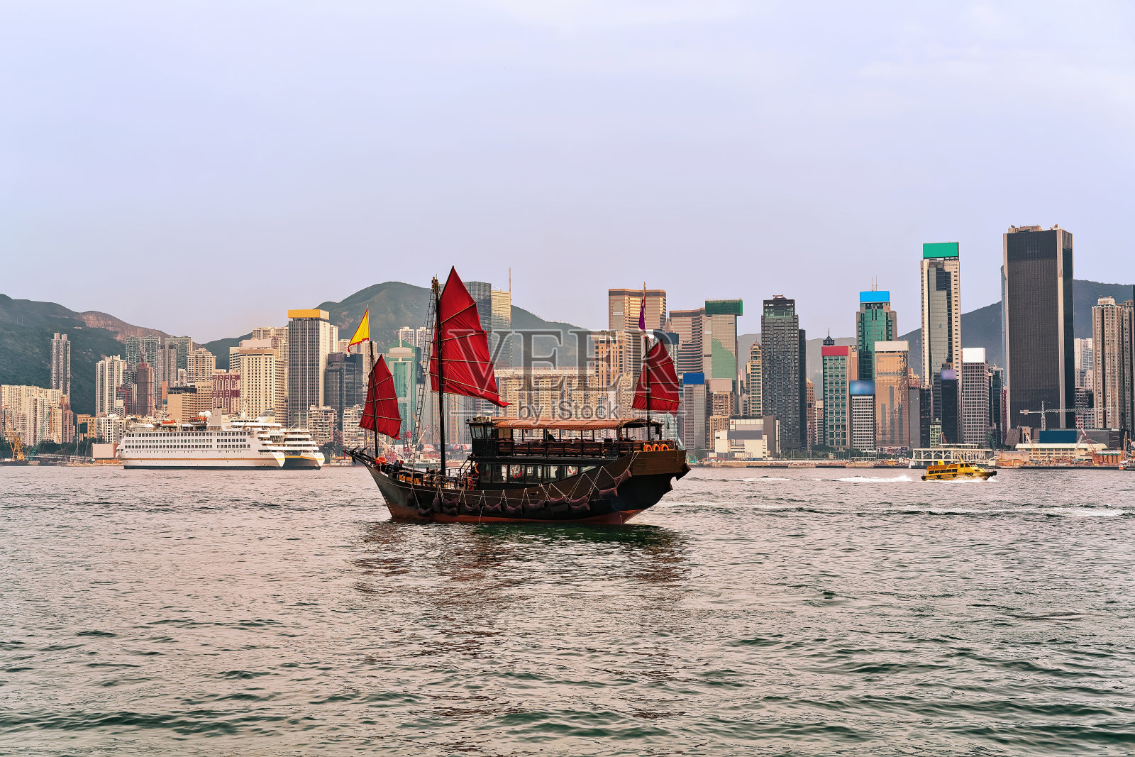 日落时香港维多利亚港上的舢板船照片摄影图片