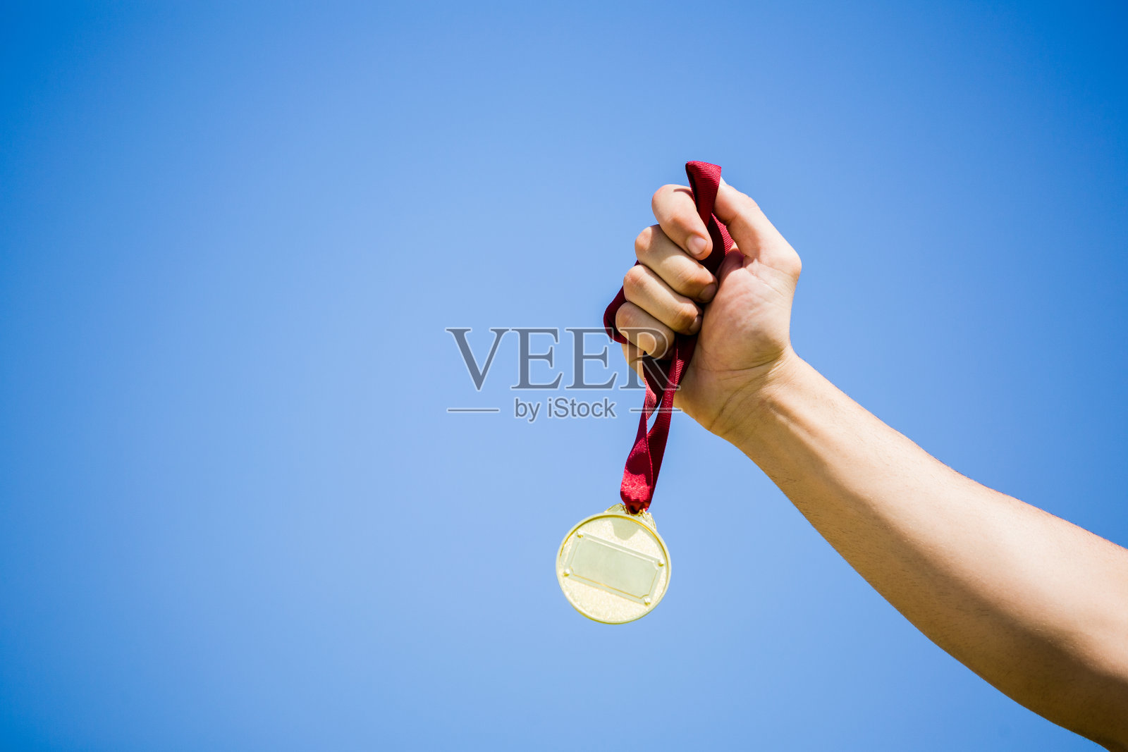 运动员在胜利后手拿金牌照片摄影图片