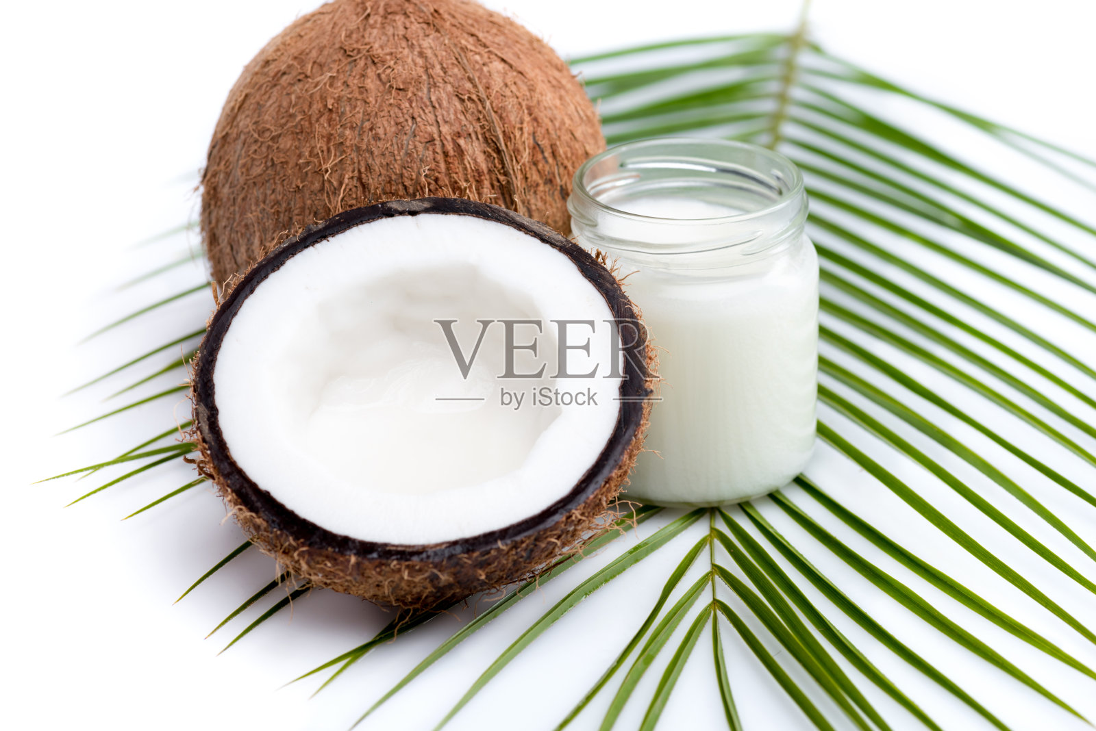 成熟椰子和有机椰子油在玻璃瓶上椰子叶孤立白色照片摄影图片