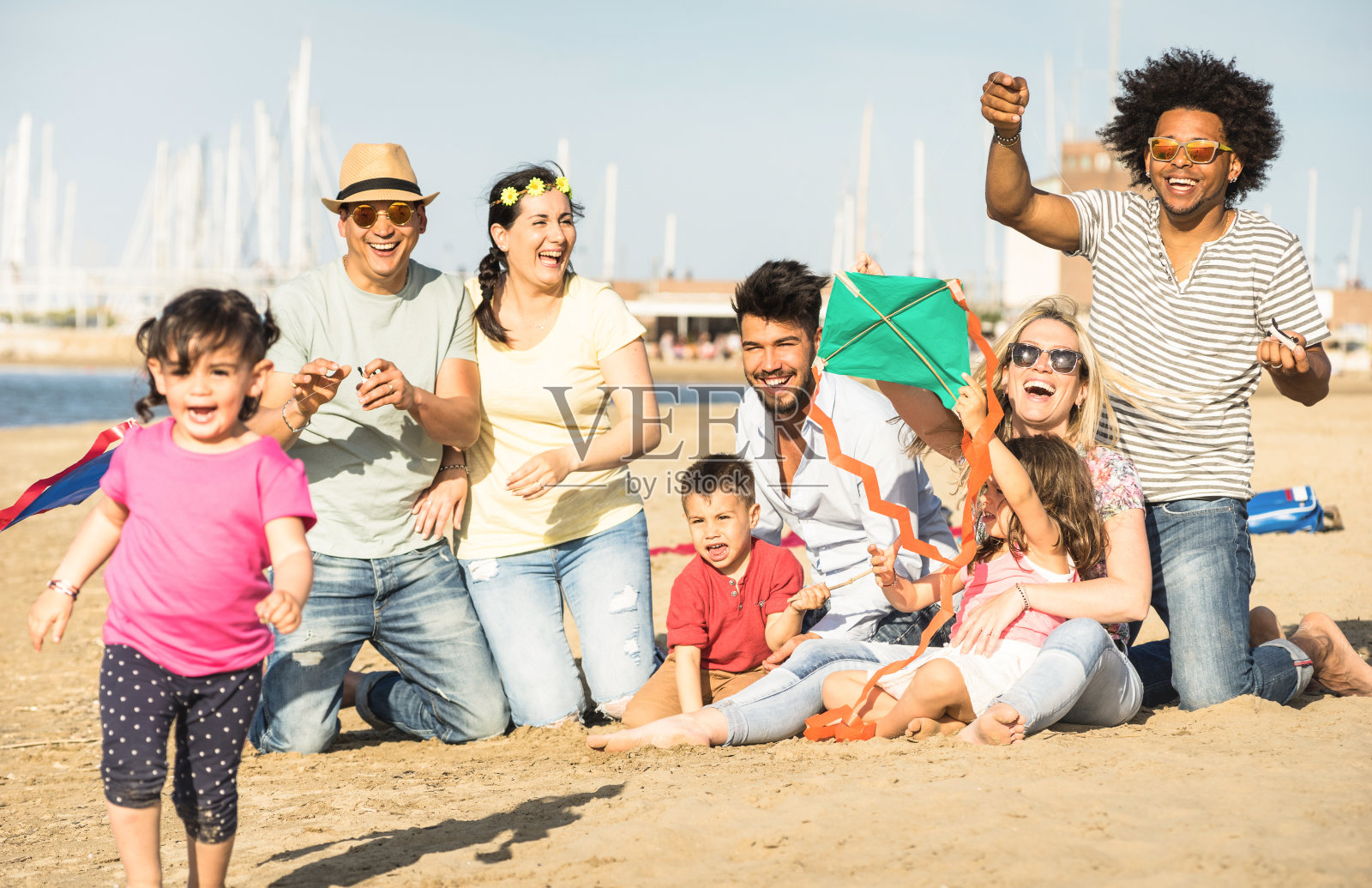 快乐的多种族家庭和孩子一起玩风筝在海滩度假-多文化的夏季喜悦概念与混合种族的人有坦率的真正的乐趣-温暖的下午色调照片摄影图片