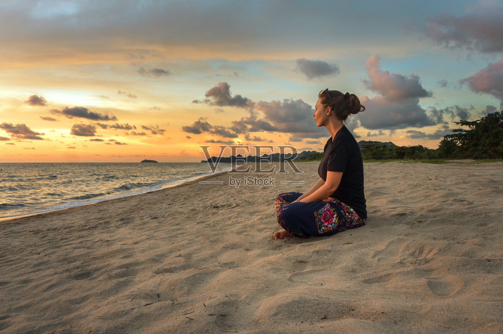 女人放松在海滩上日落照片摄影图片