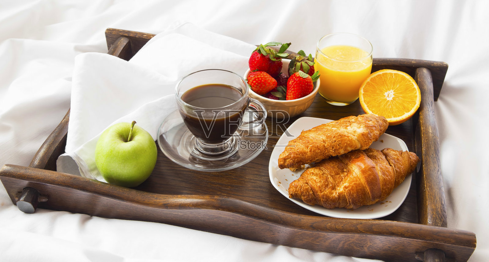 床上早餐有羊角面包，水果，咖啡和果汁照片摄影图片