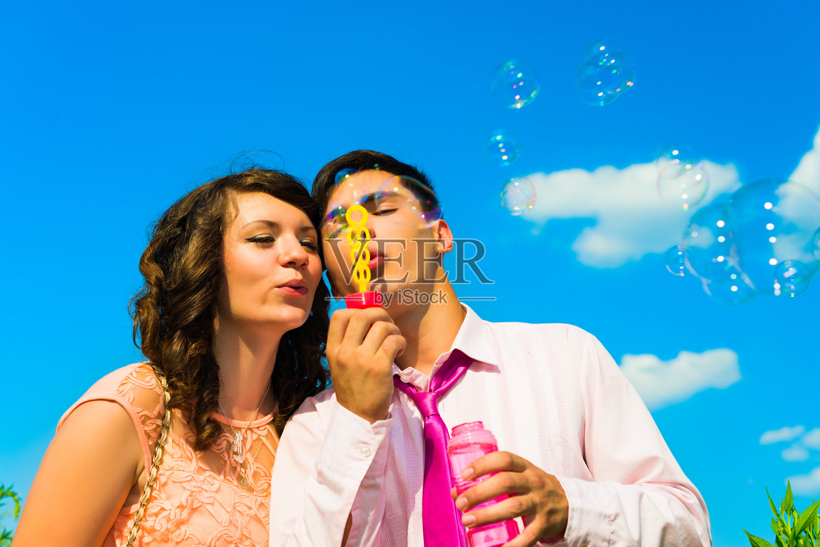 那对快乐的年轻夫妇，带着肥皂泡。照片摄影图片