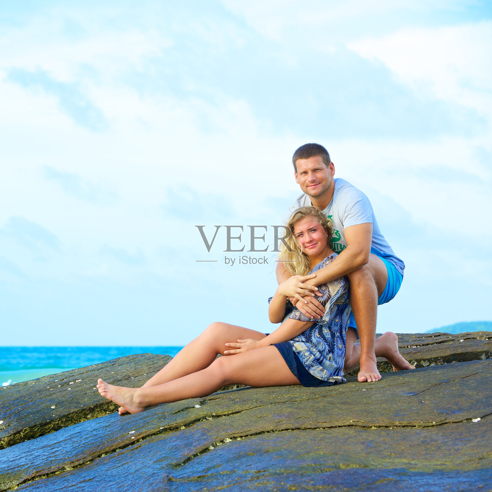 一对幸福的情侣坐在沙滩上照片摄影图片