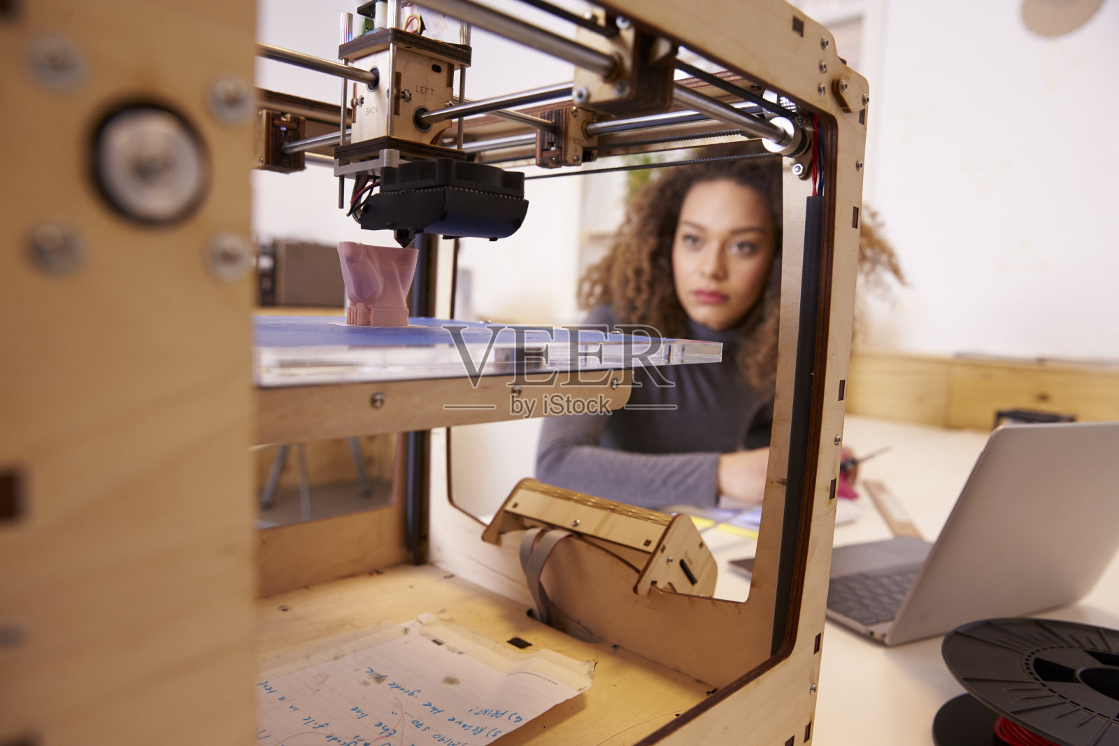 在设计工作室与3D打印机工作的女性设计师照片摄影图片
