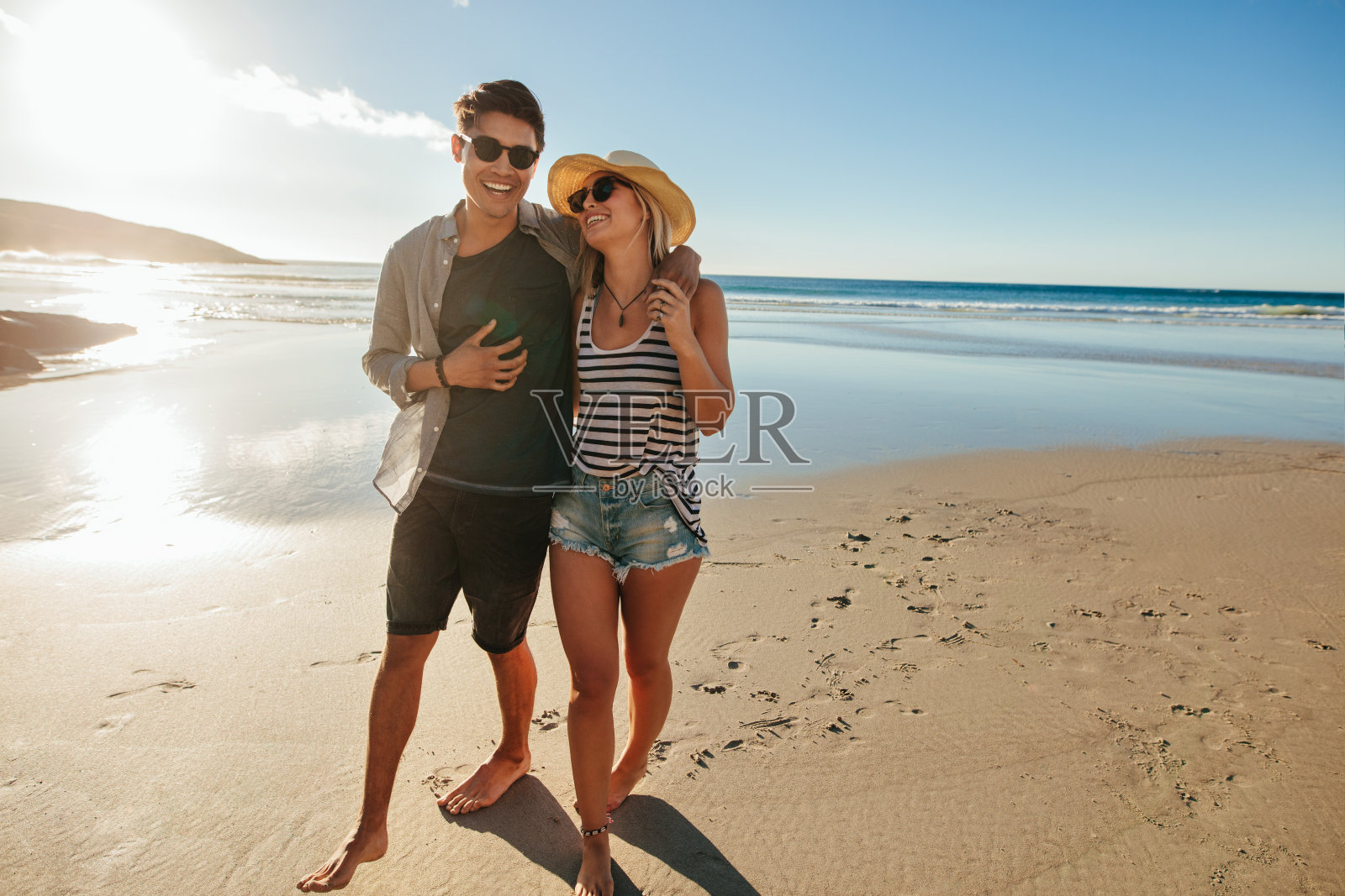 浪漫的年轻夫妇在海滩上散步照片摄影图片
