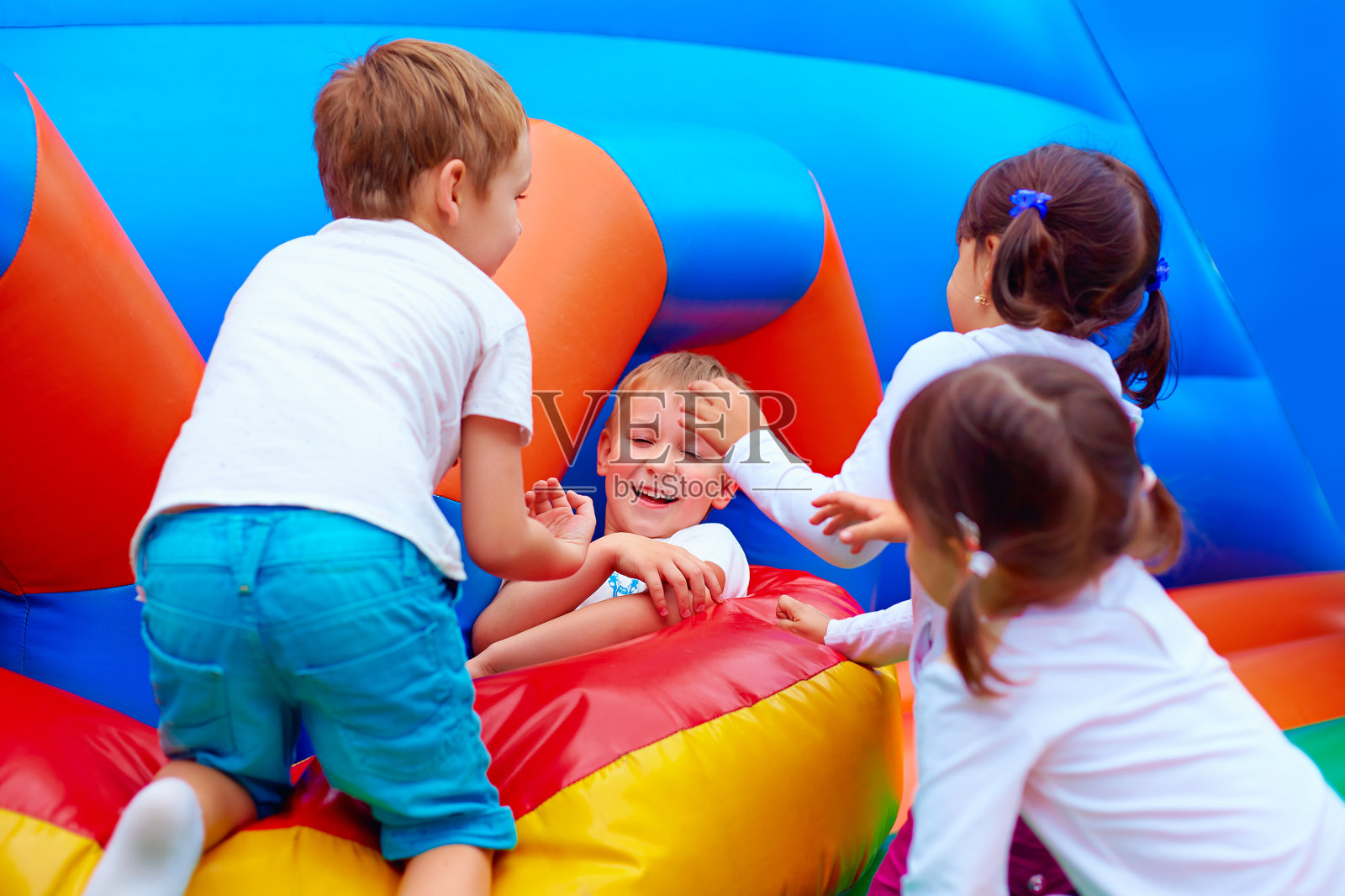 兴奋的孩子在充气吸引力游乐场上玩得很开心照片摄影图片