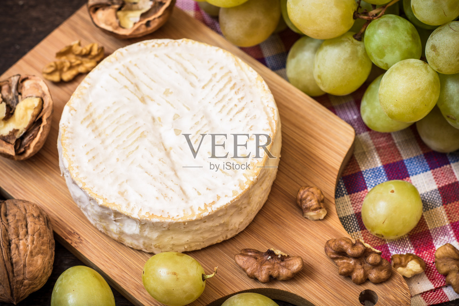 卡芒贝尔奶酪与核桃和绿葡萄在木制的乡村背景照片摄影图片