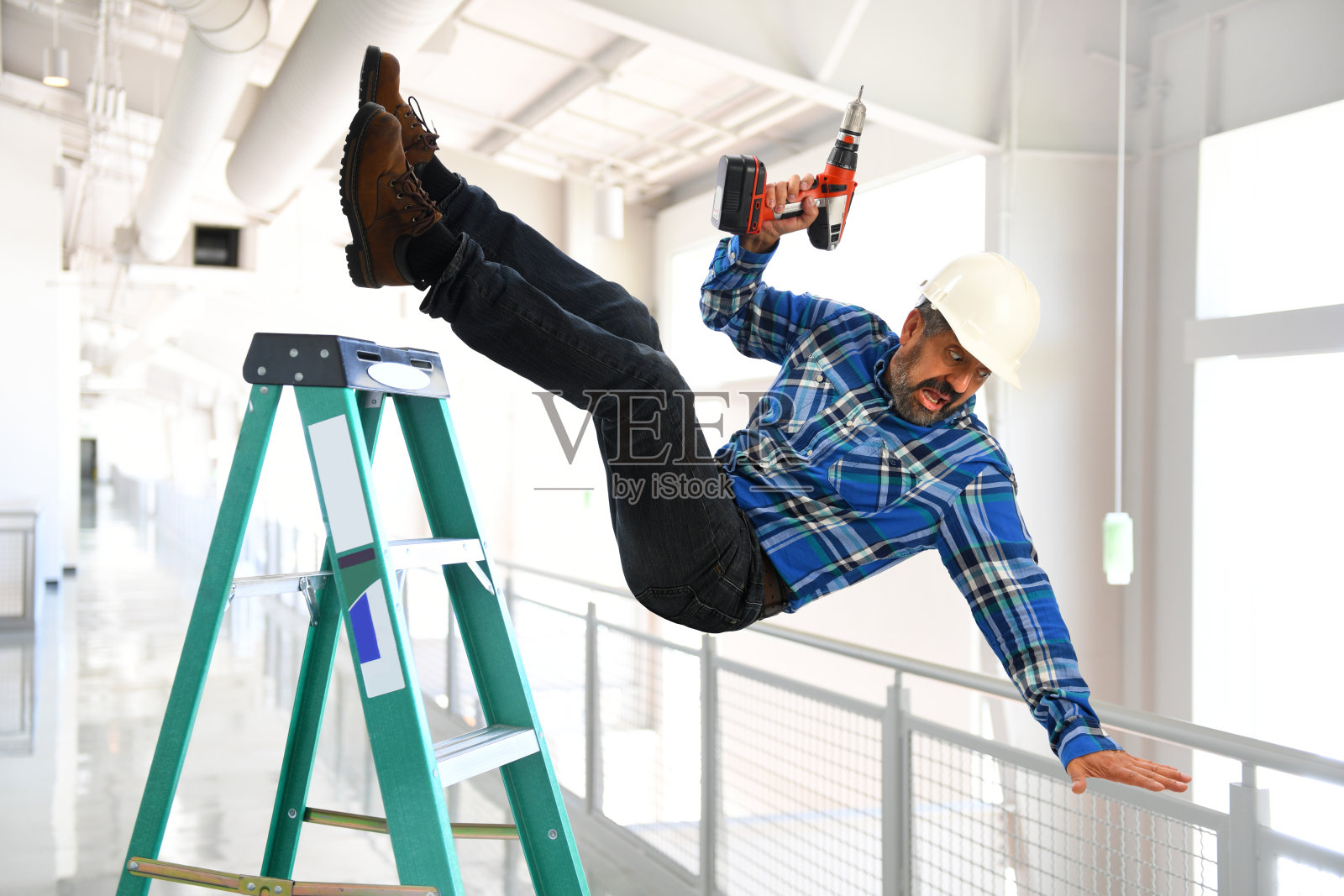 西班牙裔工人从梯子上掉下来照片摄影图片