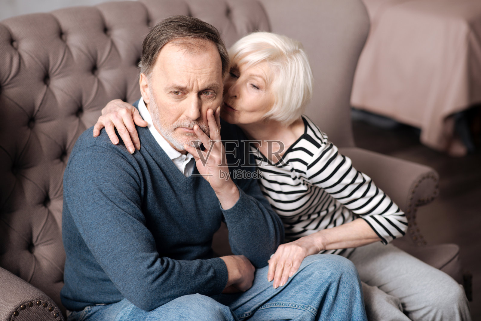 年长的女士亲吻她生病的丈夫照片摄影图片