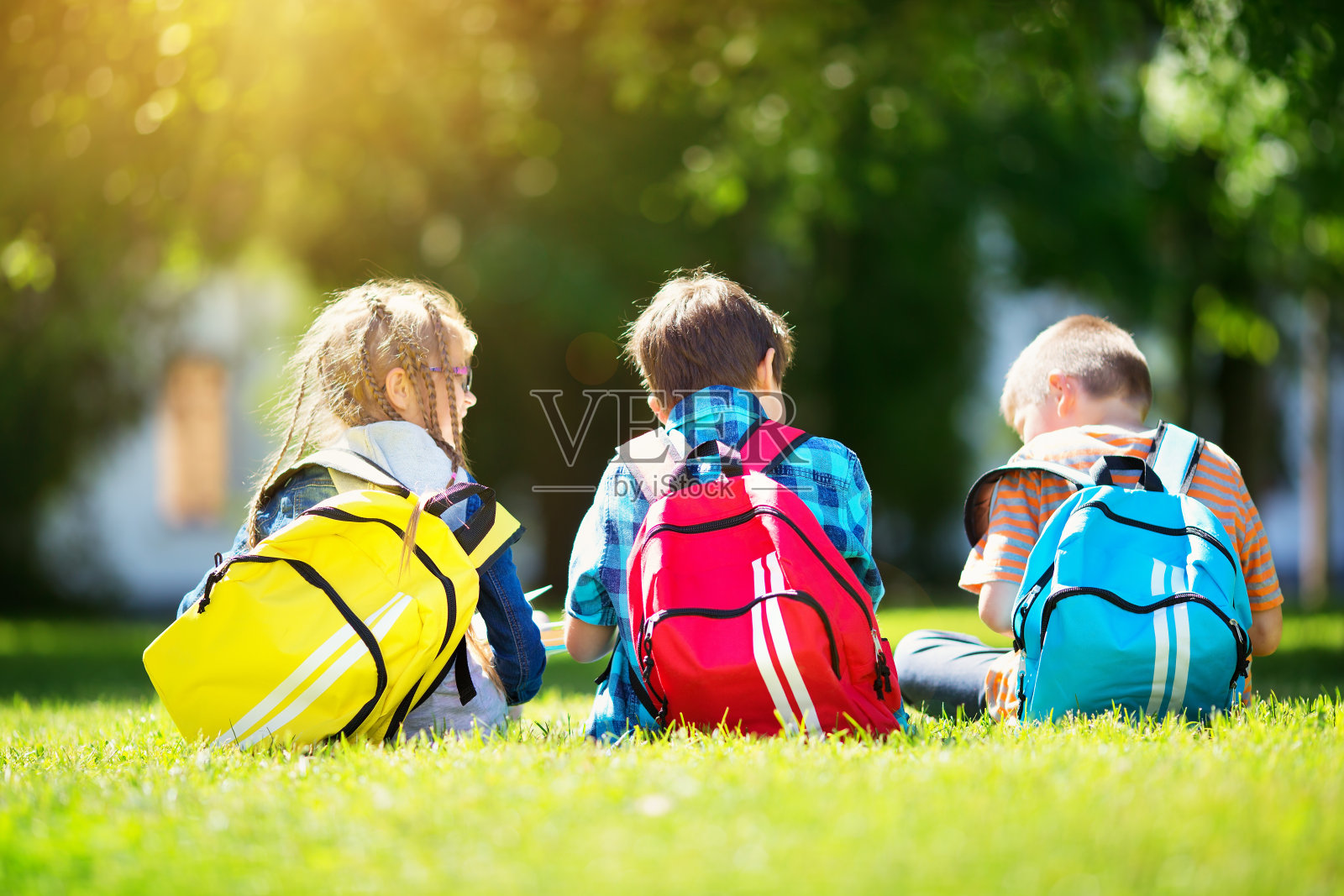 孩子们背着背包站在学校附近的公园里照片摄影图片